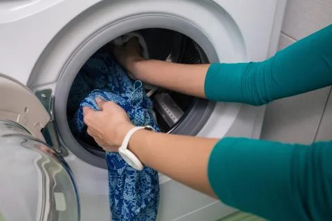 Putting a cloth into washing machine Stock Photos