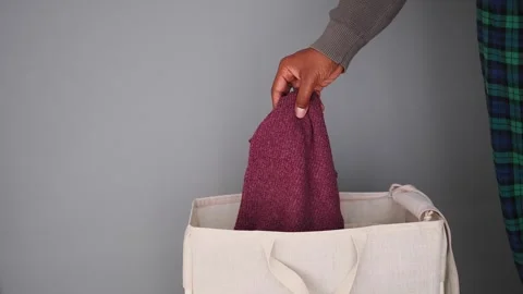 Putting clothes in a laundry bag for washing Stock Footage 342212177