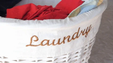 Putting clothes in the laundry basket Stock Footage 87496734