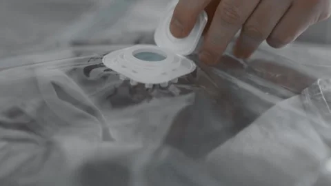 Putting clothes into vacuum bag for storage. Wardrobe storage concept. Stock Footage 305313392