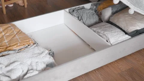 Putting clothes in vacuum bag into under the bed storage. Wardrobe storage conce Stock Footage 305313965