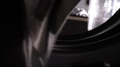 Putting the clothes in the washing machine inside out view Stock Footage 128198760