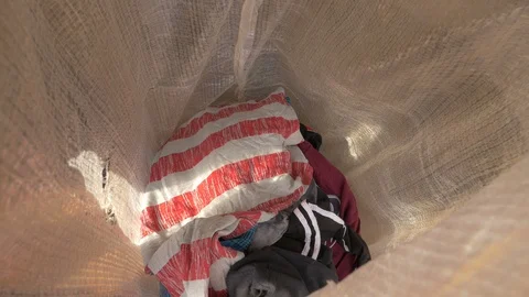 Putting clothes in a white bag Stock Footage 87079524