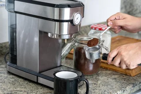 Putting the coffee in the filter with a spoon for a coffee at home Stock Photos