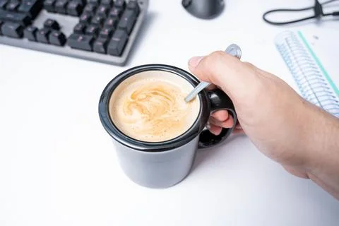 Putting coffee with milk at work time in home office Stock Photos