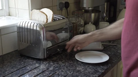 Putting a couple of slices of White Bread in the toaster Stock Footage 111707594