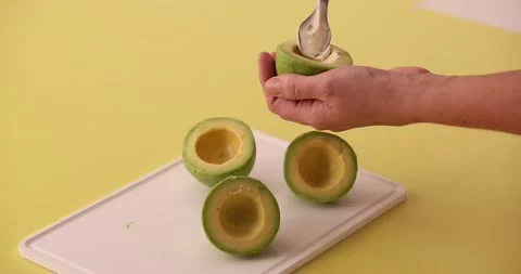 Putting cream cheese inside of avocado halves 2 Stock Footage 132136869