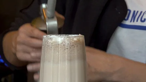 Putting cream on iced latte Stock Footage 113217887