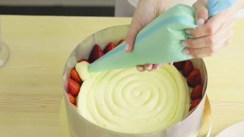 Putting cream on a sponge cake. making strawberry cake. Stock Footage 132320445