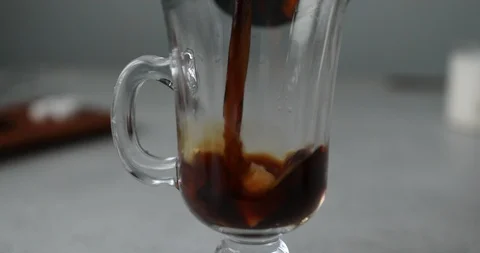 Putting cube sugar and coffee in glass cup and stirring to melt Stock Footage 119428159