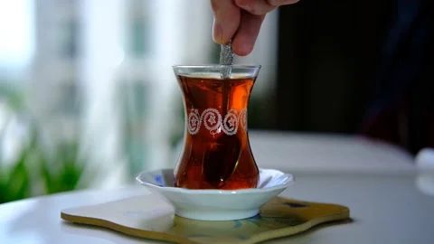 Putting Cube sugar into the Turkish Black tea and mix them with tea spoon Stock Footage 156050991