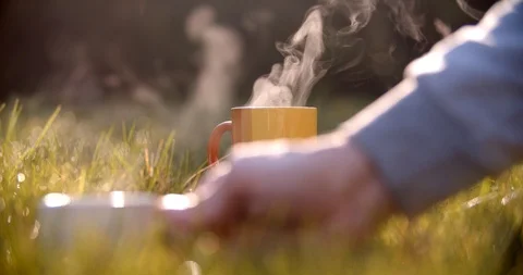Putting cup of hot drink into the grass.Self-isolation in countryside. Stock Footage 128324518