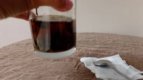 Putting a cup of tea on a brown table Stock Footage 145629827