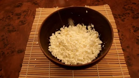 Putting the curd into a deep brown ceramic bowl Stock Footage 83273932