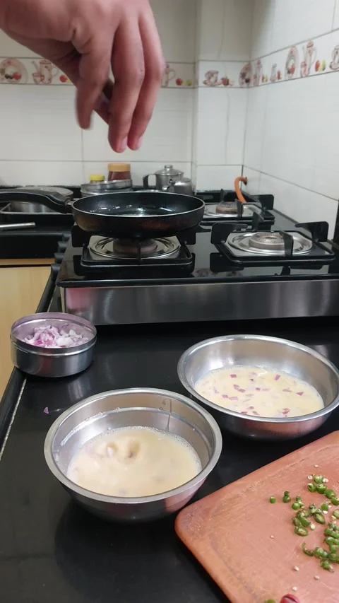 Putting cut onion into bowl while making egg omlet Stock Footage 235484527