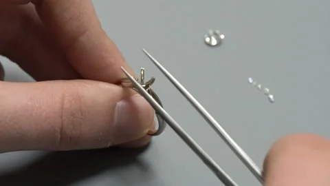 Putting the diamond on the white gold solitaire ring. Diamond ring product Stock Footage 139727149