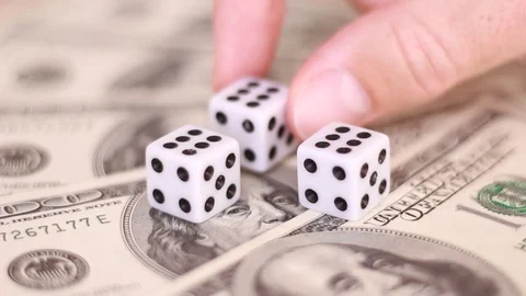 Putting dice over dollar banknotes Stock Footage 98480394