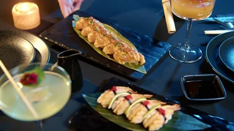 Putting of different kinds of sushi on table close-up. Top view of seafood Stock Footage 239103139
