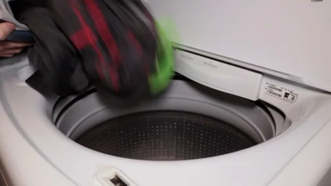 Putting Dirty Laundry and a Detergent Pod into a Washing Machine Stock Footage 100723431