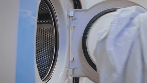 Putting dirty laundry into the washing machine Stock Footage 98429953
