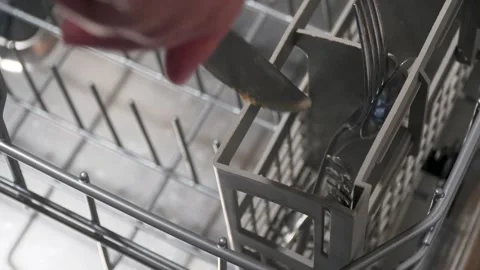 Putting dirty silverware into a dishwasher basket Vídeos de archivo 313908025