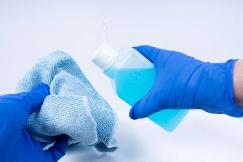 Putting disinfectant onto a cloth for cleaning Stock Photos