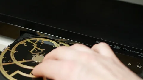 Putting disk in blu-ray player, DVD, audio CD, SACD Stock Footage 90205780