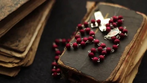 Putting down Bible and Rosary Stock Footage 75950371