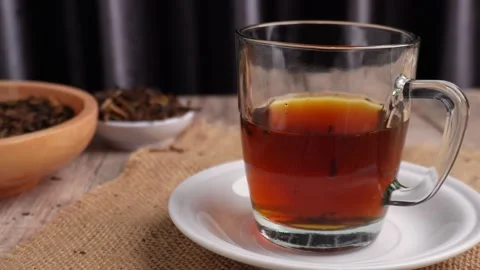 Putting down a cup of tea on saucer by hand onto table 库存影片 273462166