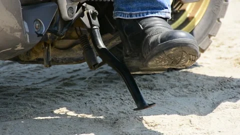 Putting down the motorcycle kickstand or side stand of a motorcycle. 스톡 동영상 221764623