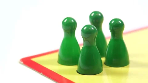 Putting down, placing 4 simple green game pieces on a board, preparing Stock Footage 171334916