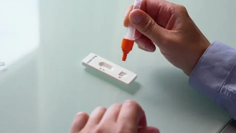 Putting a drop of reactive fluid into the cassette of rapid home  test for .. Video stock 281588770