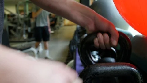 Putting Exercise Weights on Shelf Medicine Balls with Hands holding Dumbbells Stock Footage 125303687
