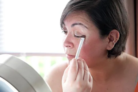 Putting on eye shadow Stock Photos