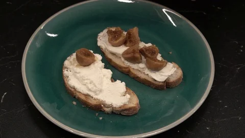 Putting figs on bread above view Stock Footage 113528449