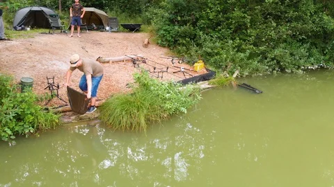 Putting a fish back into the lake  Video stock 112180157