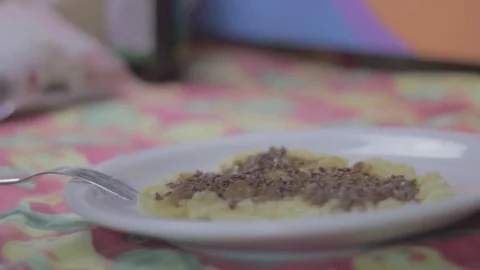 Putting flax seed on a smashed banana in a plate Stock Footage 79537367