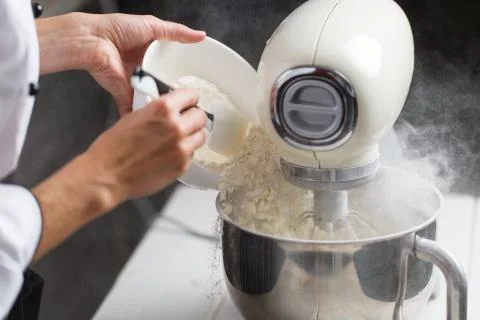 Putting flour in mixer Stock Photos