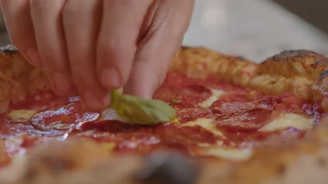 Putting Fresh Basil Leaf on Baked Pizza Stock Footage 261889922