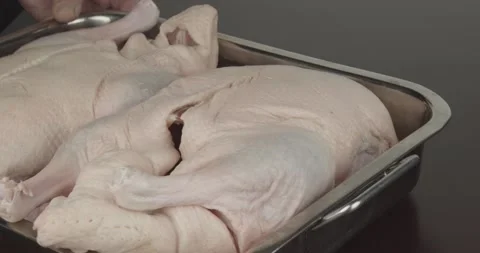 Putting fresh ducks in a roasting tin onto a board Stock Footage 155347436