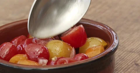 Putting fresh tomato salad into a tapas clay bowl Stock Footage 142628066