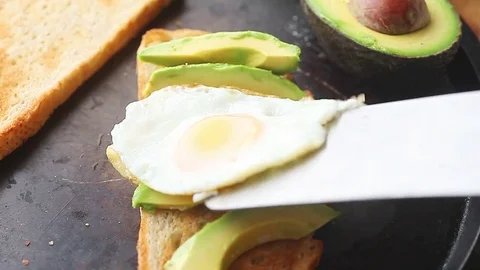 Putting fried egg atop avocado toast Stock Footage 78167287