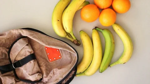 Putting fruits into old backpack after grocery shopping Stock Footage 105585665