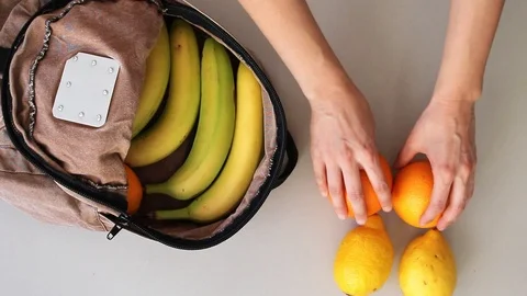 Putting fruits into old backpack after grocery shopping Stock Footage 105585774