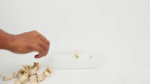 Putting Garlic into a Transparent Square Jar Stock Footage 327852671
