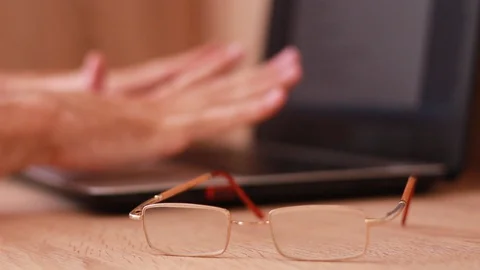 Putting glasses off and warming hands up while working on computer Stock Footage 88763947