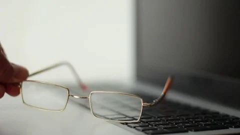 Putting glasses on the notebook and taking it back Vídeos de archivo 77178537