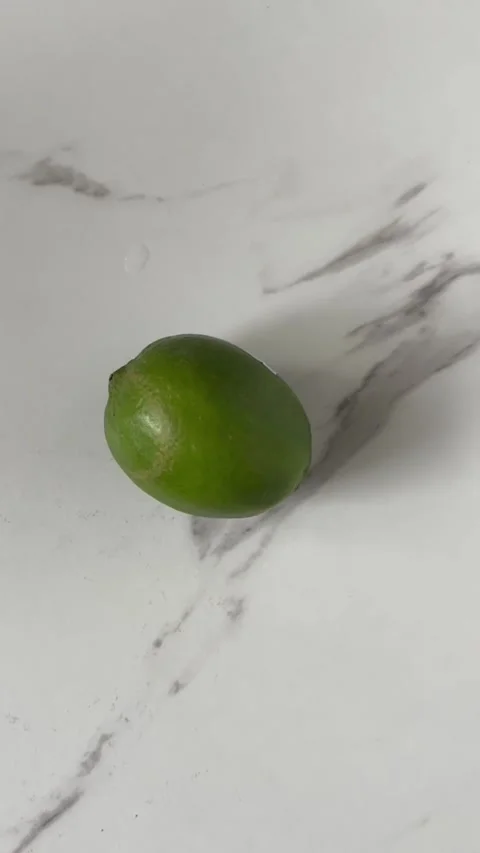 Putting a green lime on a counter Stock Footage 289689890