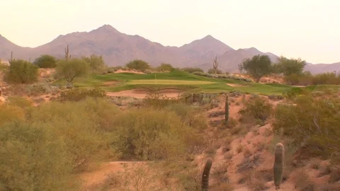 Putting green surrounded by cactus cacti with mountains Stock Footage 125277772