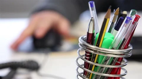 Putting hand on computer mouse, focus from pens Stock Footage 58753489